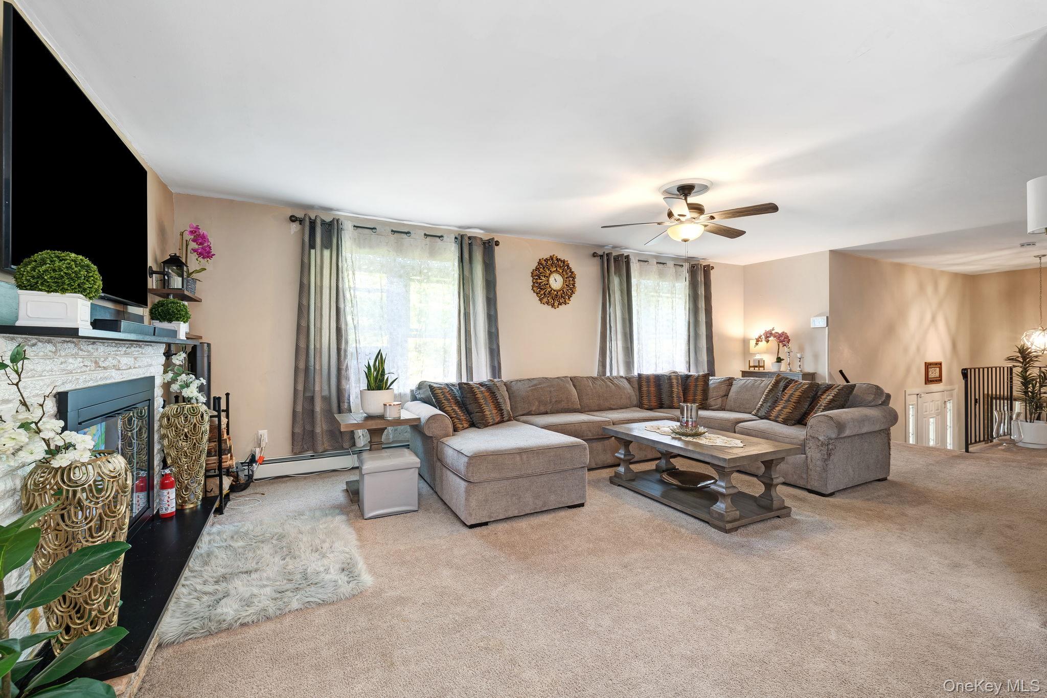 6 Farmstead Road New Windsor, NY 12553 - Photo 10 of 32 Living room with carpet, a fireplace, a ceiling fan, and a baseboard radiator