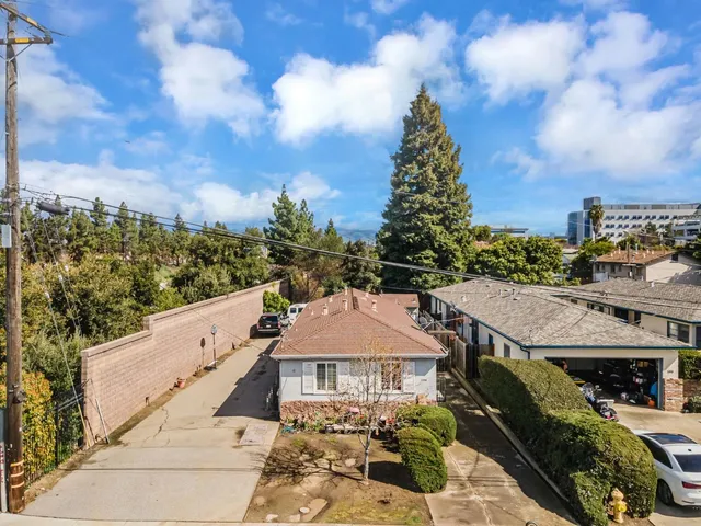 a backyard of a house with chairs and wooden fence