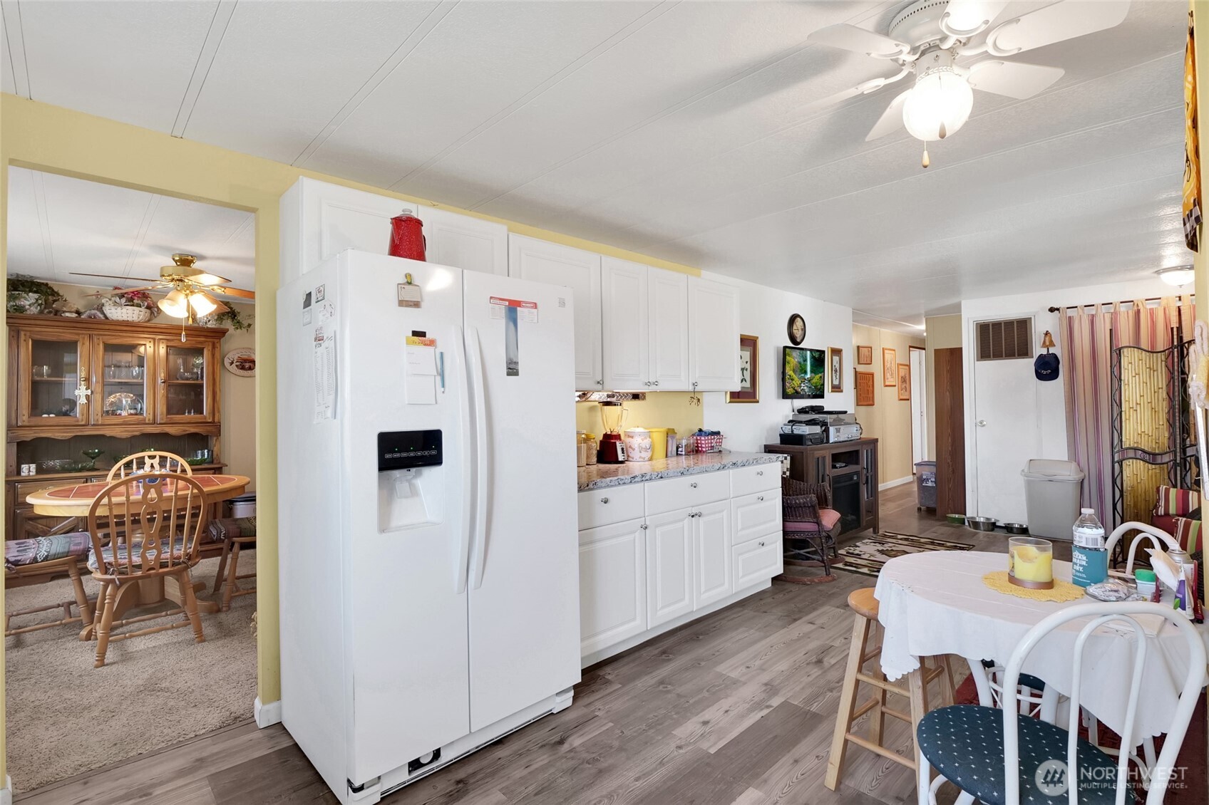 9630 Rd H.8 Northeast Moses Lake, WA 98837 - Photo 14 of 39 a kitchen with refrigerator a sink dishwasher a dining table and chairs with wooden floor
