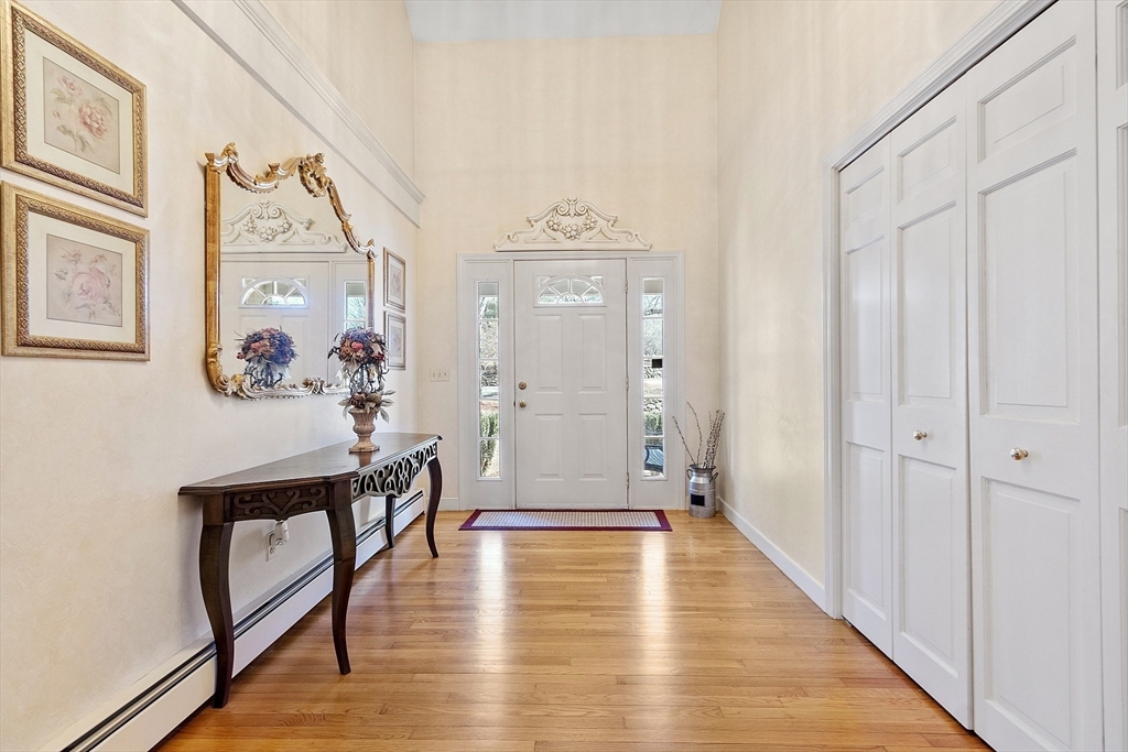 2 Abigail Drive Hudson, MA 01749 - Photo 6 of 42 a view of a hallway to a livingroom with wooden floor and furniture