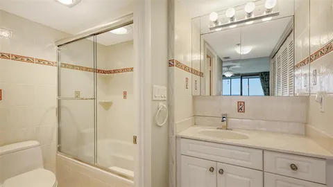 a bathroom with a shower sink vanity mirror and toilet