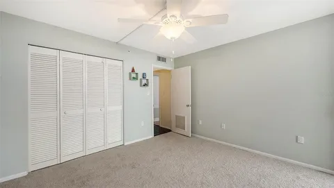 an empty room with a ceiling fan and a window