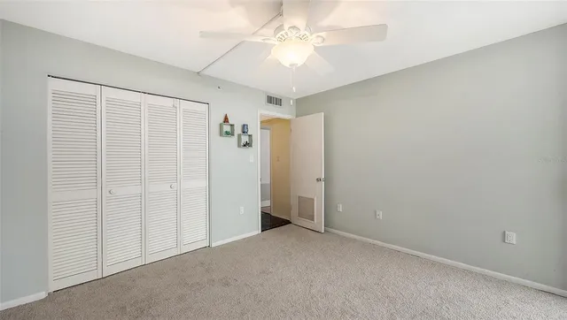 an empty room with a ceiling fan and a window