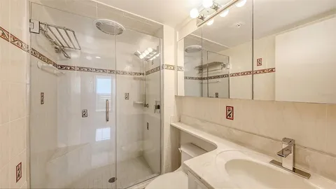 a bathroom with a sink vanity granite shower and a mirror