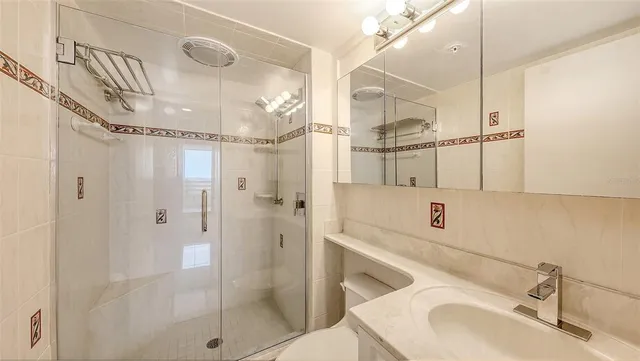 a bathroom with a sink vanity granite shower and a mirror