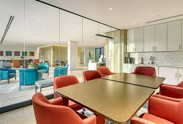 a room with stainless steel appliances dining table chairs and view kitchen