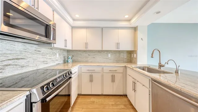a kitchen with stainless steel appliances granite countertop a sink stove and cabinets