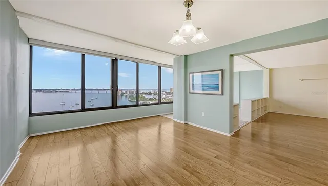 a view of an empty room with a window and wooden floor