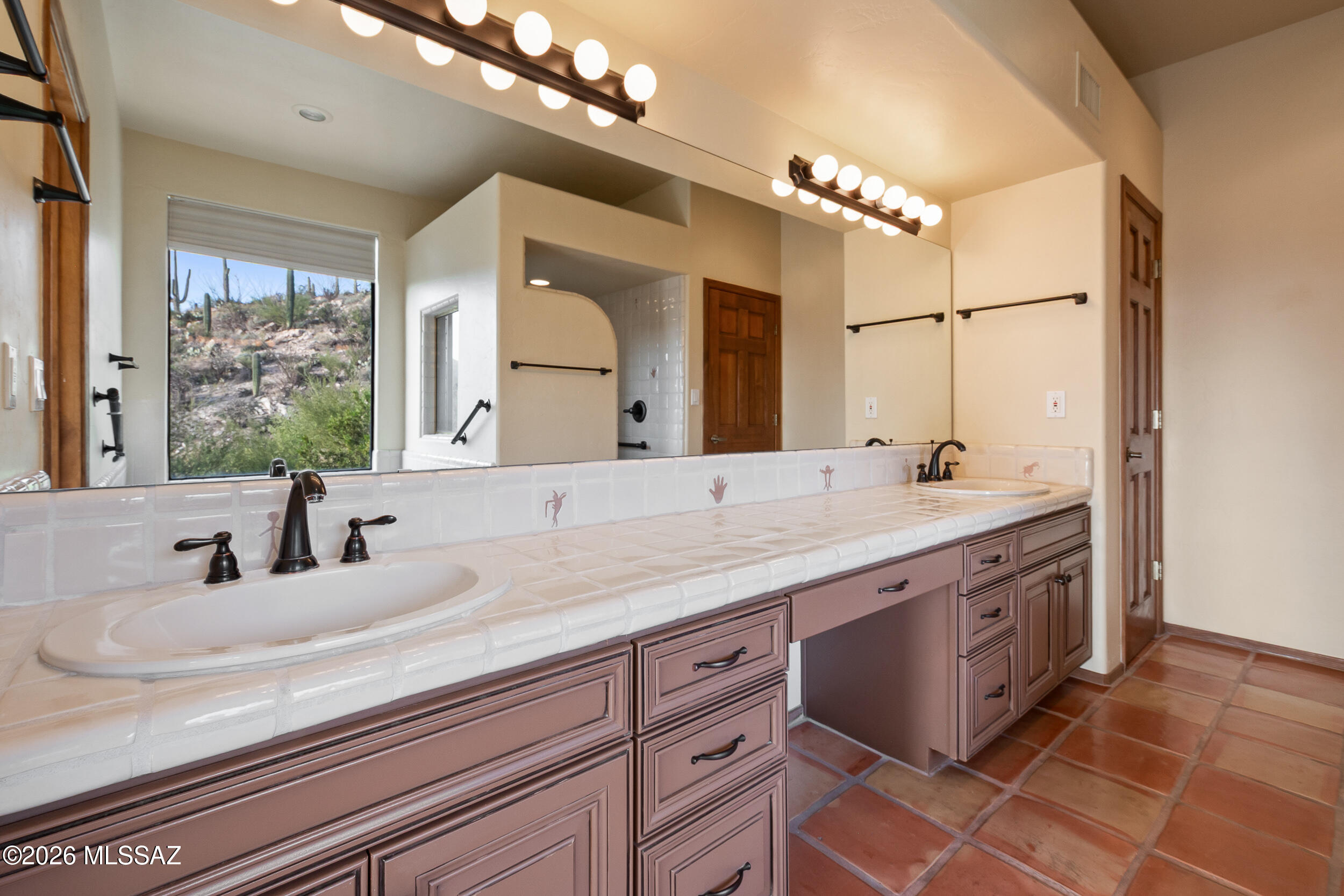 13630 East Sahuaro Sunset Road Tucson, AZ 85749 - Photo 17 of 47 a bathroom with a double vanity sink and a mirror
