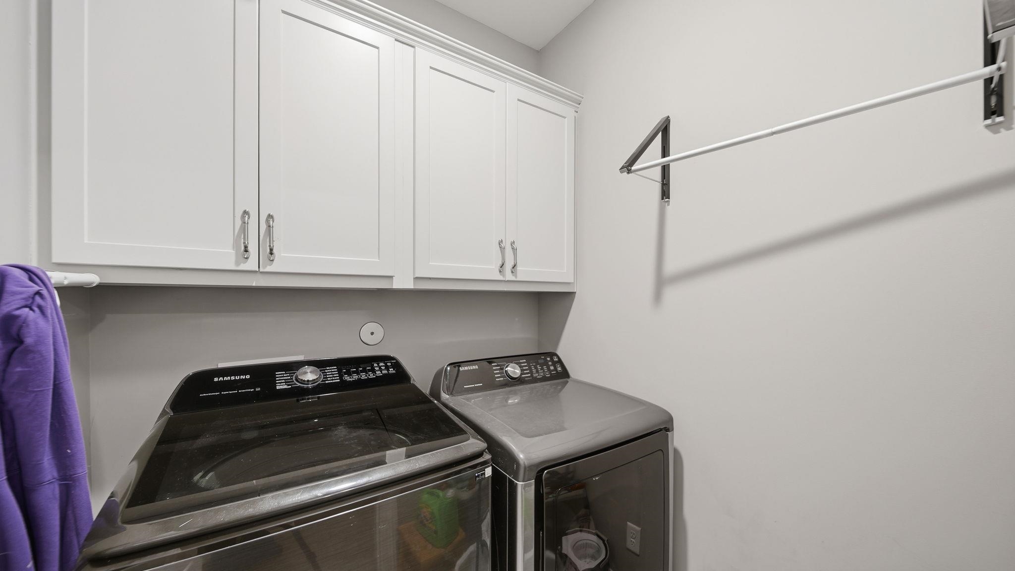 70 Trinity Cove Atoka, TN 38004 - Photo 12 of 25 Laundry area featuring upper cabinetry with brushed nickel hardware and a wall-mounted drying rack