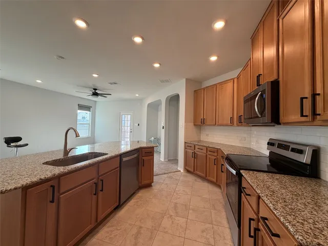 a kitchen with granite countertop sink stainless steel appliances and cabinets