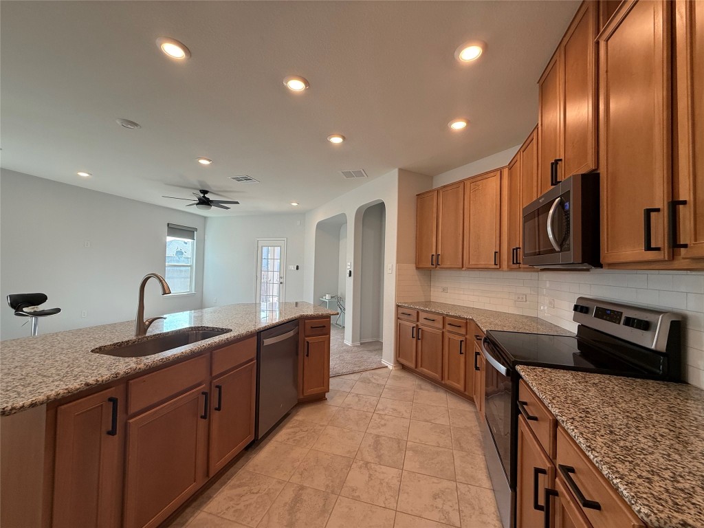 a kitchen with granite countertop sink stainless steel appliances and cabinets