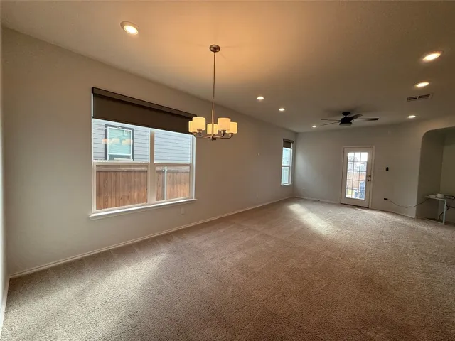 a view of a livingroom with a ceiling fan & entryway