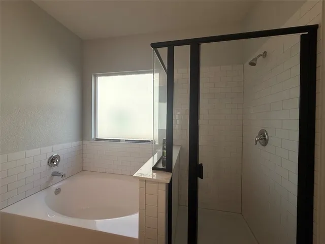 a bathroom with a tub sink and mirror