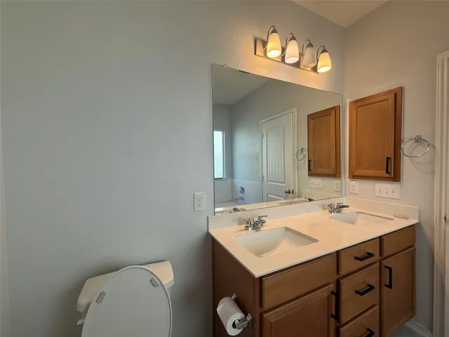 a bathroom with a toilet sink and mirror