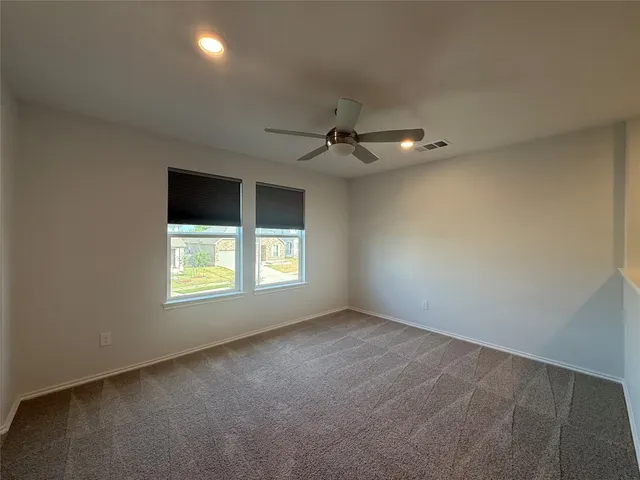 an empty room with a ceiling fan and a window