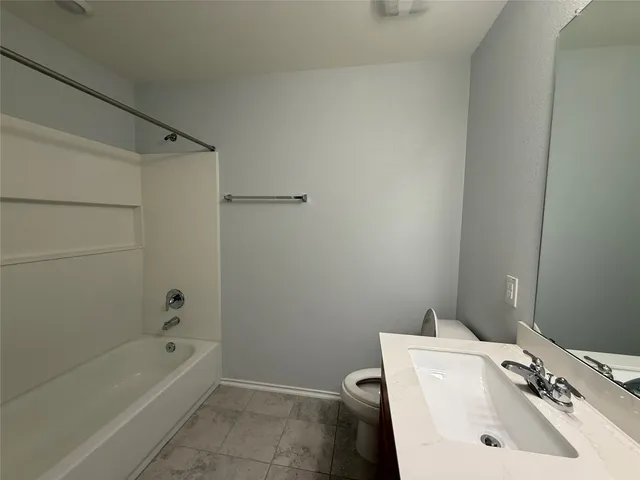 an empty room with a window and a ceiling fan