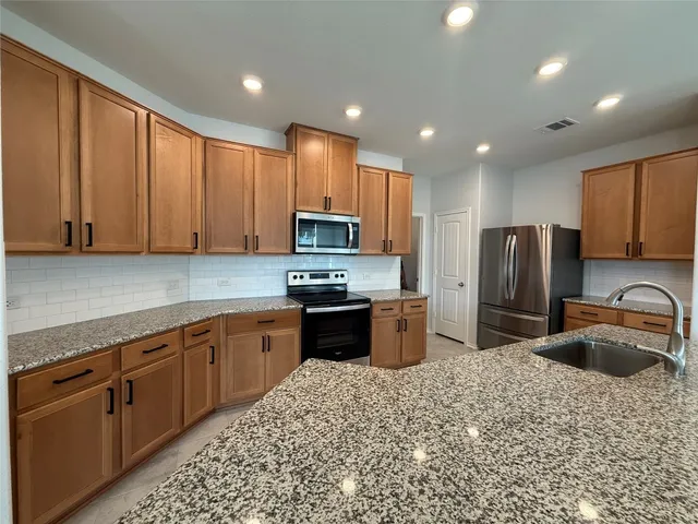 a kitchen with a sink a microwave and appliances