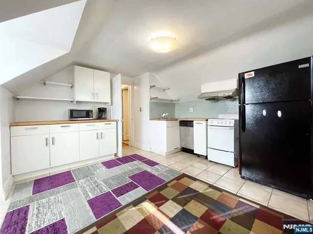 a kitchen with white cabinets and appliances