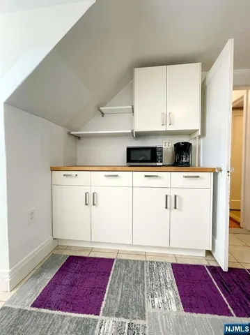 a view of a kitchen with wooden floor and cabinets
