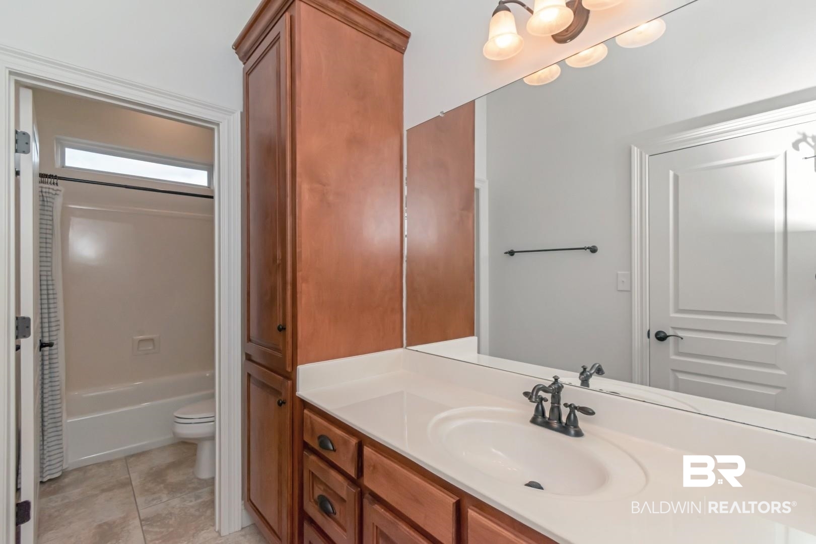 30585 Pine Court Daphne, AL 36527 - Photo 19 of 49 Full bathroom featuring vanity, shower / bath combo with shower curtain, and light tile patterned flooring