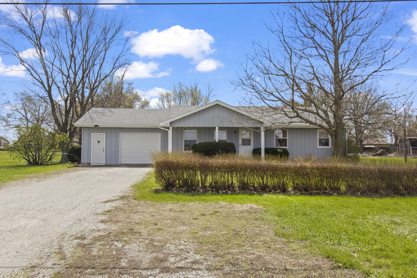 a front view of a house with a garden and yard
