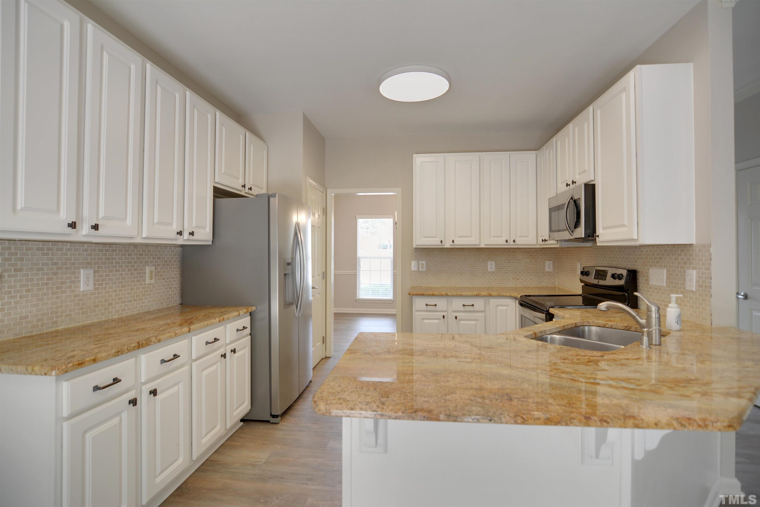 8400 Astwell Court Raleigh, NC 27615 - Photo 8 of 21 a kitchen with stainless steel appliances granite countertop a sink stove and refrigerator