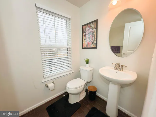 a bathroom with a sink toilet and a mirror