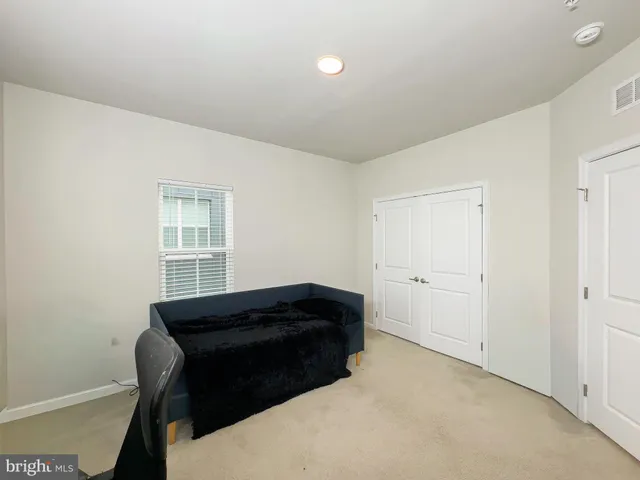 a bathroom with a granite countertop sink a toilet a mirror and a window