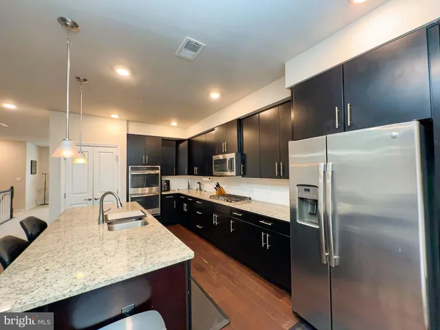 a large kitchen with kitchen island a sink stove and refrigerator