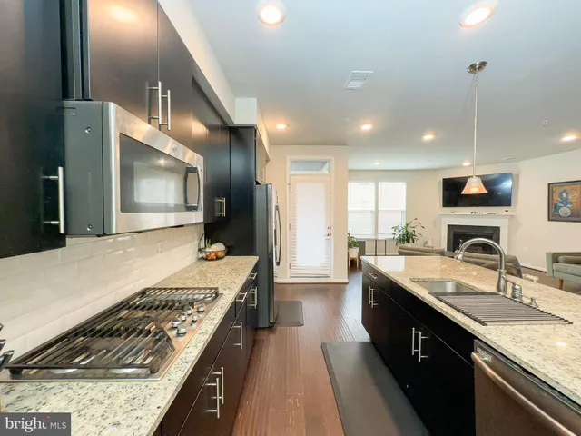 a large kitchen with kitchen island a sink stainless steel appliances and a counter top