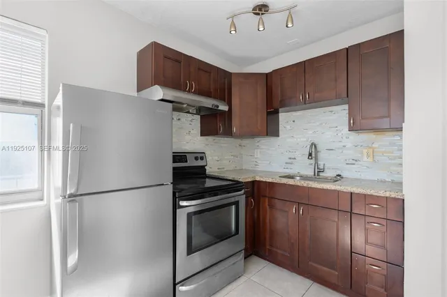 a kitchen with stainless steel appliances a refrigerator sink and cabinets