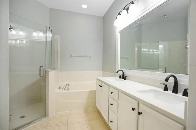 a bathroom with a tub sink and mirror