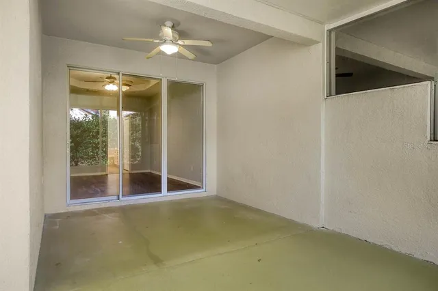 an empty room with a ceiling fan and window