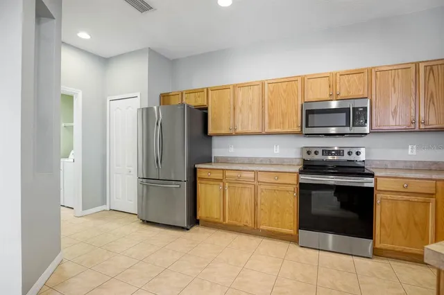 a kitchen with stainless steel appliances granite countertop a stove a refrigerator and a stove top oven