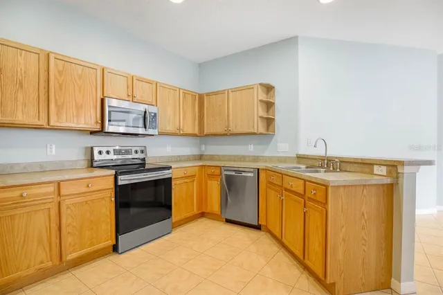 a kitchen with stainless steel appliances granite countertop a stove a sink and a microwave