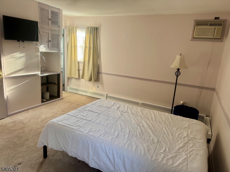 9 Windsor Drive Oak Ridge, NJ 07438 - Photo 31 of 50 a bedroom with a bed and a flat screen tv