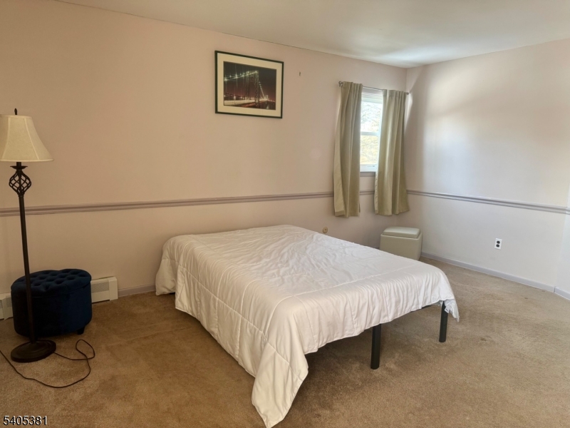 9 Windsor Drive Oak Ridge, NJ 07438 - Photo 34 of 50 a bedroom with a bed and a potted plant on the dresser