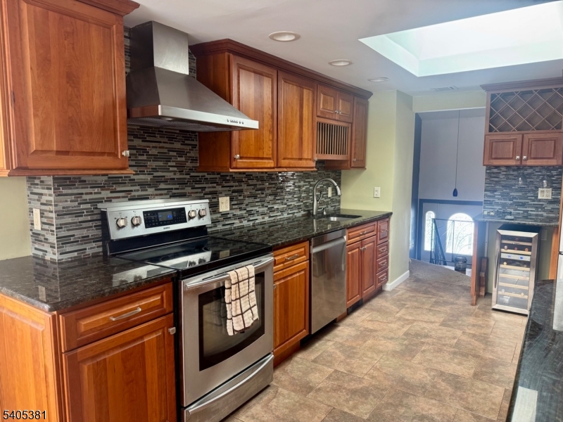 9 Windsor Drive Oak Ridge, NJ 07438 - Photo 48 of 50 a kitchen with stainless steel appliances granite countertop a stove a sink and a microwave