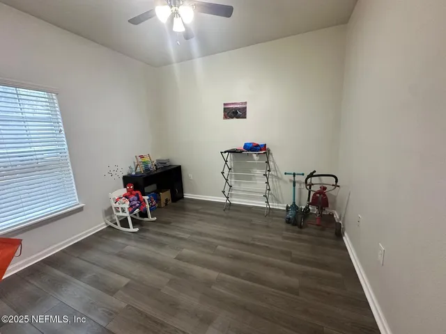 a view of a room with wooden floor and chairs