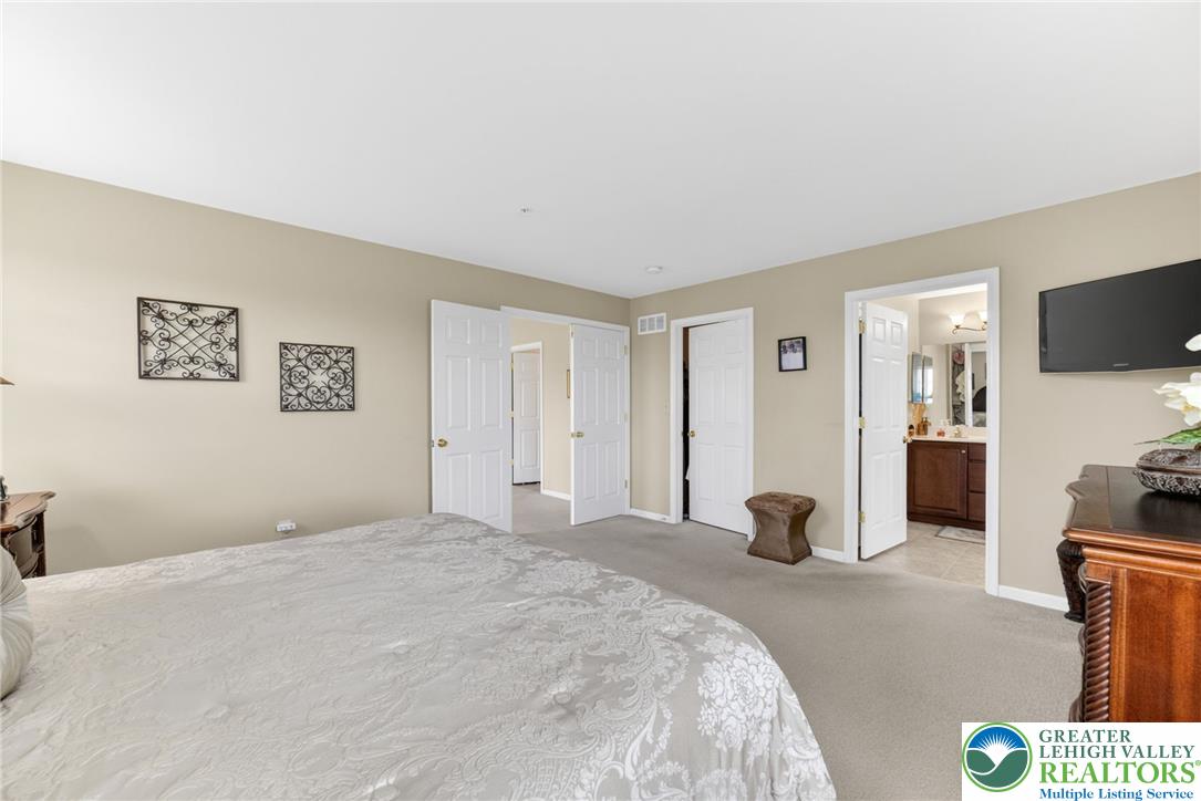 5440 Spring Ridge Drive West Macungie, PA 18062 - Photo 19 of 40 A comfortable bedroom with soft carpeting and convenient access to an en-suite bathroom.