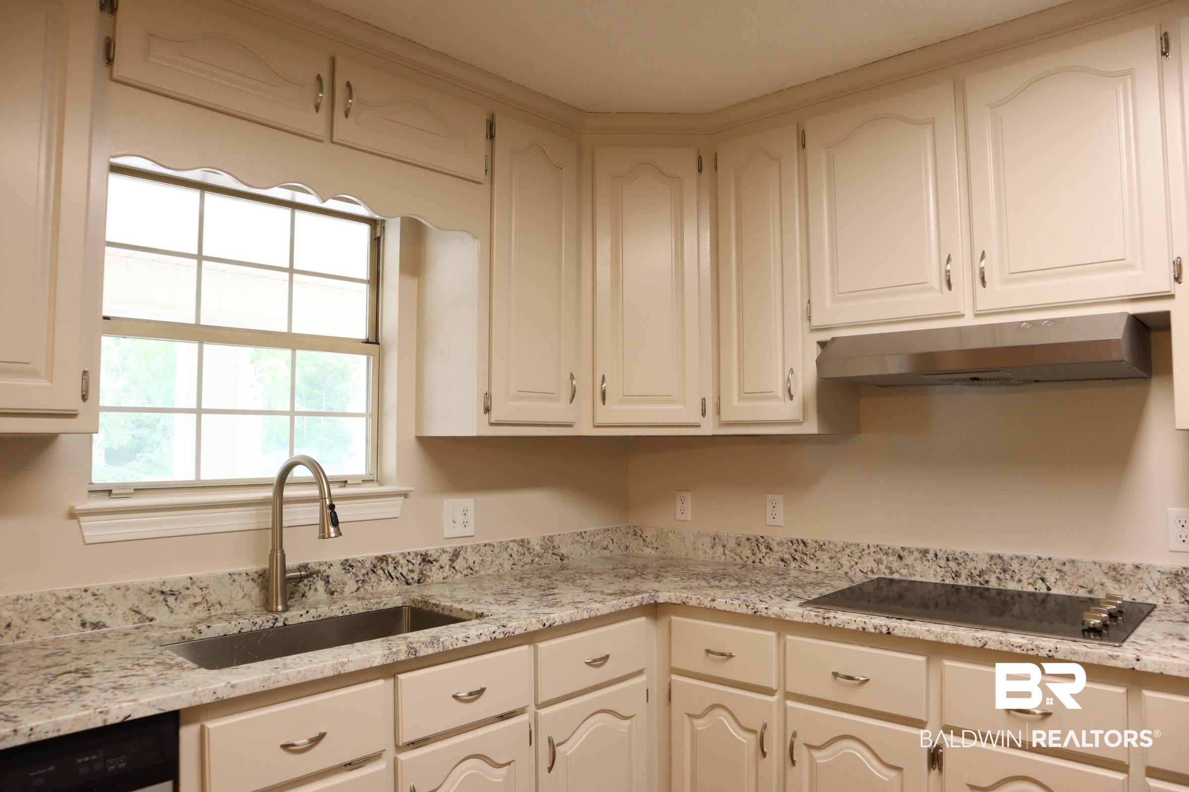 12150 Lee Bishop Road Irvington, AL 36544 - Photo 11 of 26 Kitchen featuring white cabinets, a sink, black electric cooktop, under cabinet range hood, and dishwashing machine