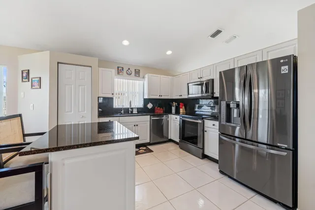 a kitchen with stainless steel appliances a refrigerator sink and cabinets