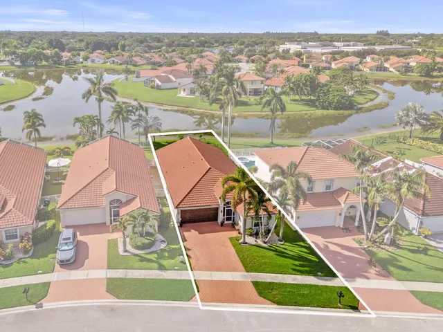 an aerial view of a house with a yard and lake view