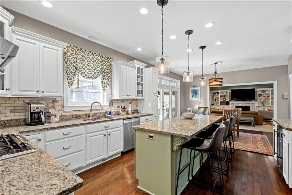 102 Lantern Circle McMurray, PA 15317 - Photo 6 of 25 a kitchen with stainless steel appliances kitchen island granite countertop a stove a sink a dining table and chairs with wooden floor