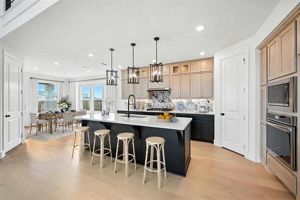 4520 Script Street Prosper, TX 75078 - Photo 2 of 27 a kitchen with stainless steel appliances granite countertop a table chairs sink refrigerator and cabinets