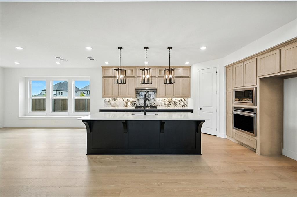 4520 Script Street Prosper, TX 75078 - Photo 6 of 27 a view of kitchen with stainless steel appliances kitchen island granite countertop a refrigerator and a sink