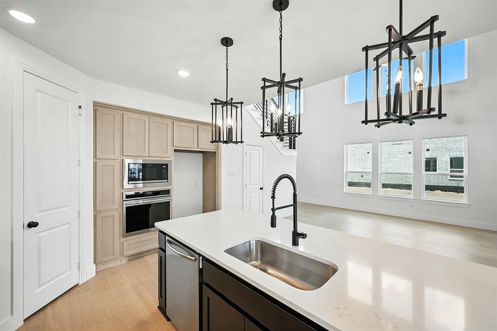 4520 Script Street Prosper, TX 75078 - Photo 8 of 27 a kitchen with stainless steel appliances a sink a stove a refrigerator and cabinets