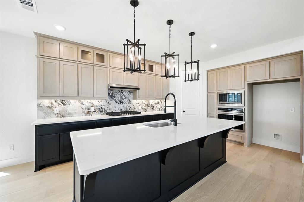4520 Script Street Prosper, TX 75078 - Photo 9 of 27 a kitchen with stainless steel appliances a sink a stove a refrigerator and cabinets