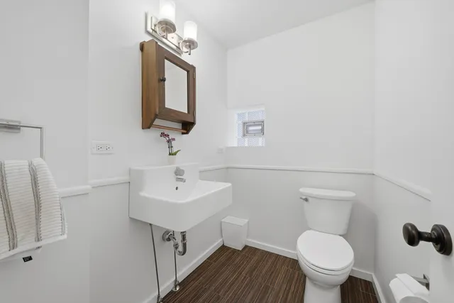 a bathroom with a toilet a sink and mirror